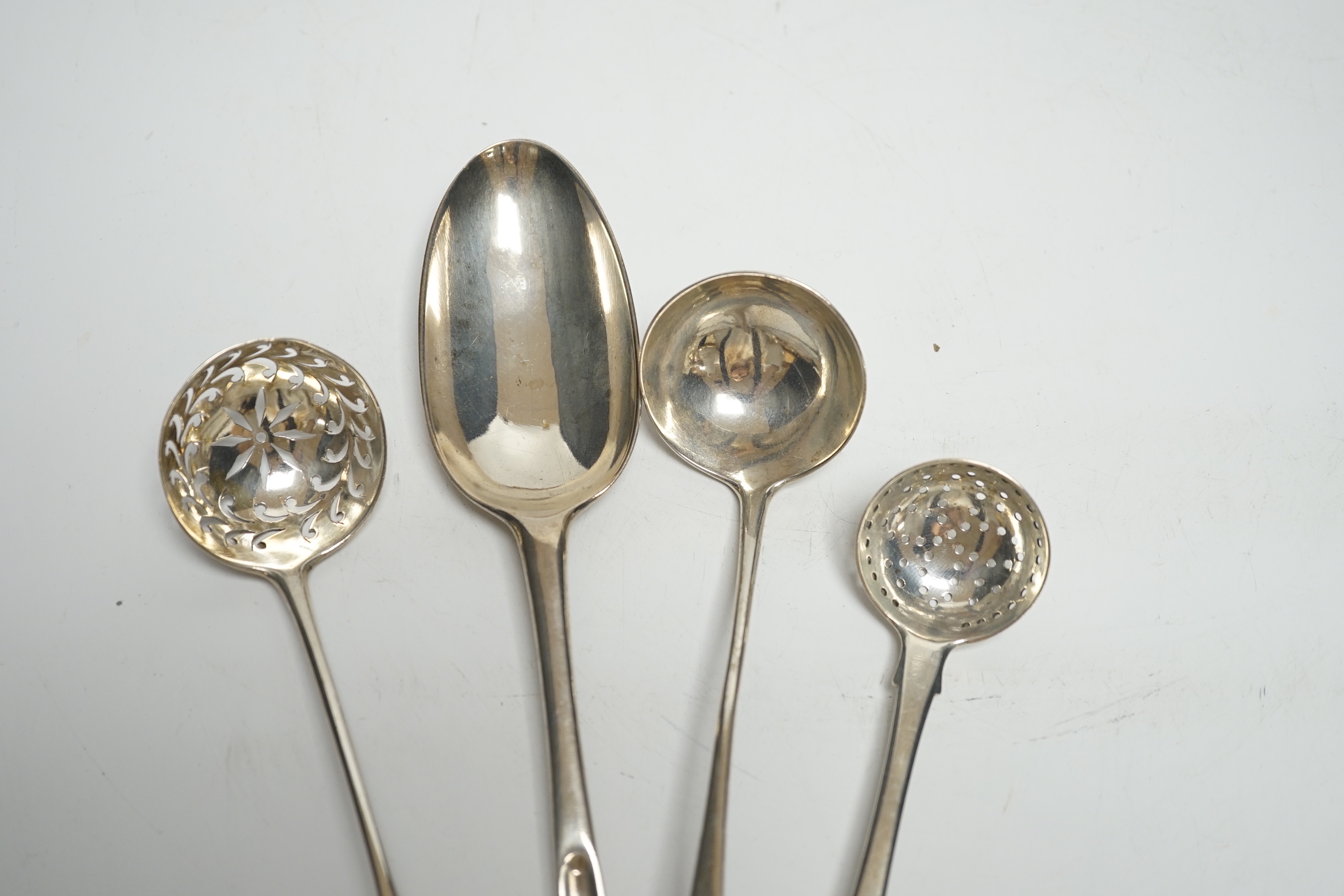 An 18th century silver spoon with marrow scoop handle, indistinct base marks, two silver sifter spoons and a white metal sauce ladle.